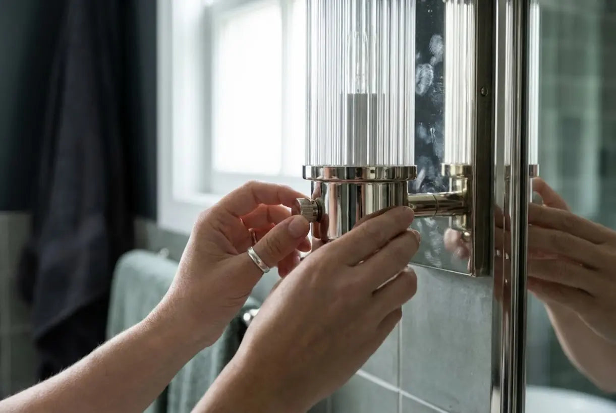 Close-up of polished nickel bathroom lighting fixture showing cool metallic finish and reflective surface quality