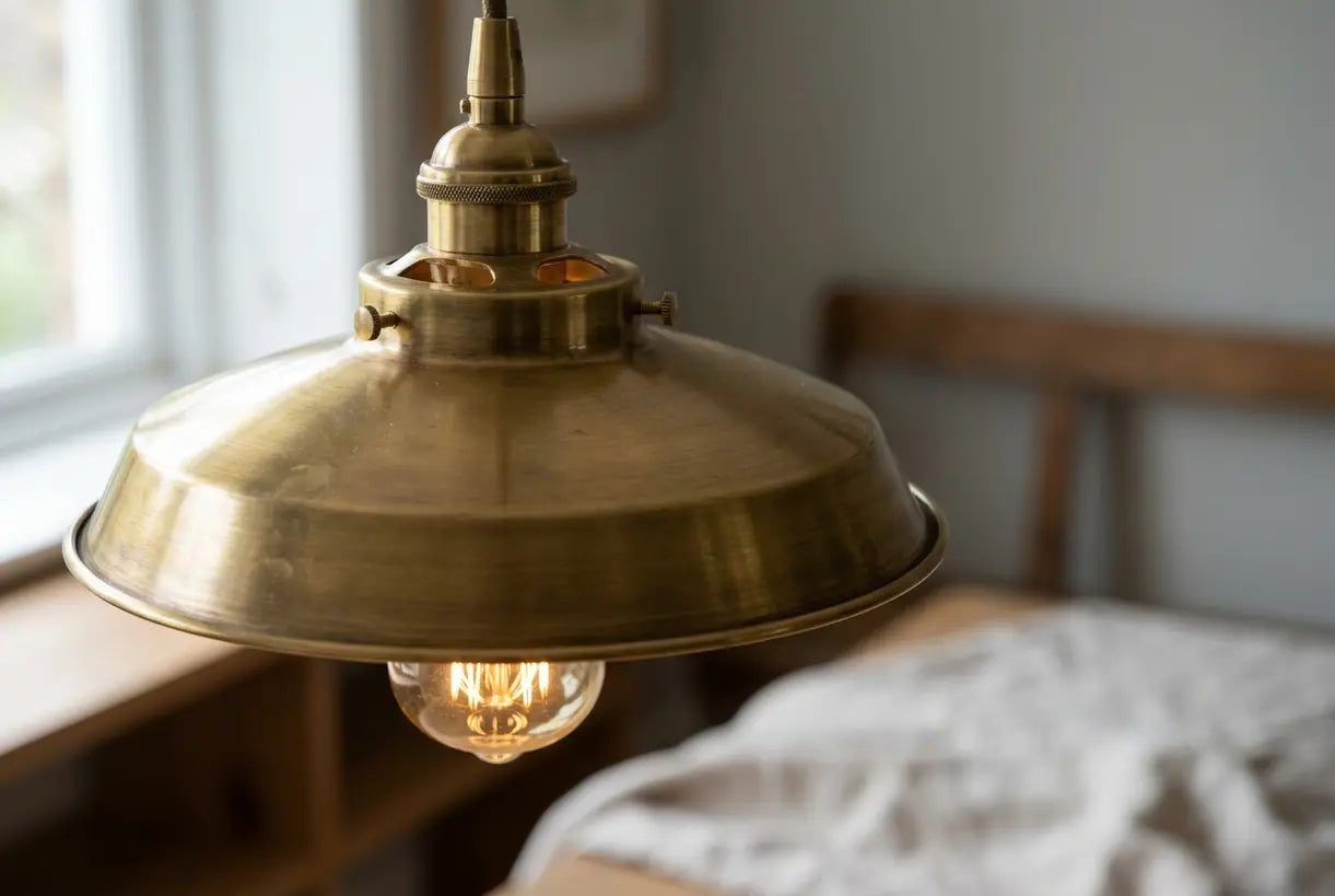 Close-up of brushed brass pendant light fixture showing warm golden texture and craftsmanship details