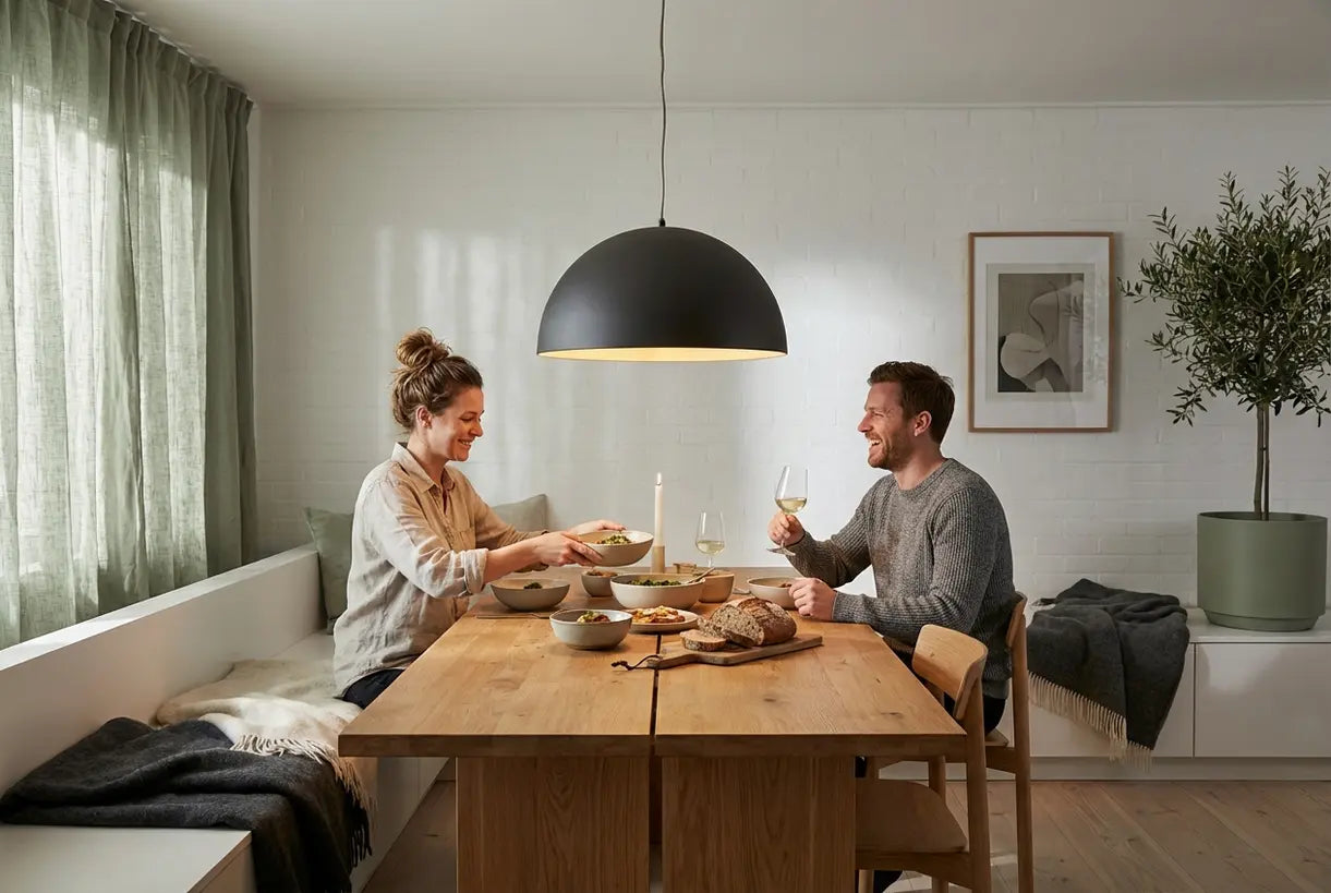 Scandinavische eetkamer met dome hanglamp boven eettafel die een warme sfeer creëert