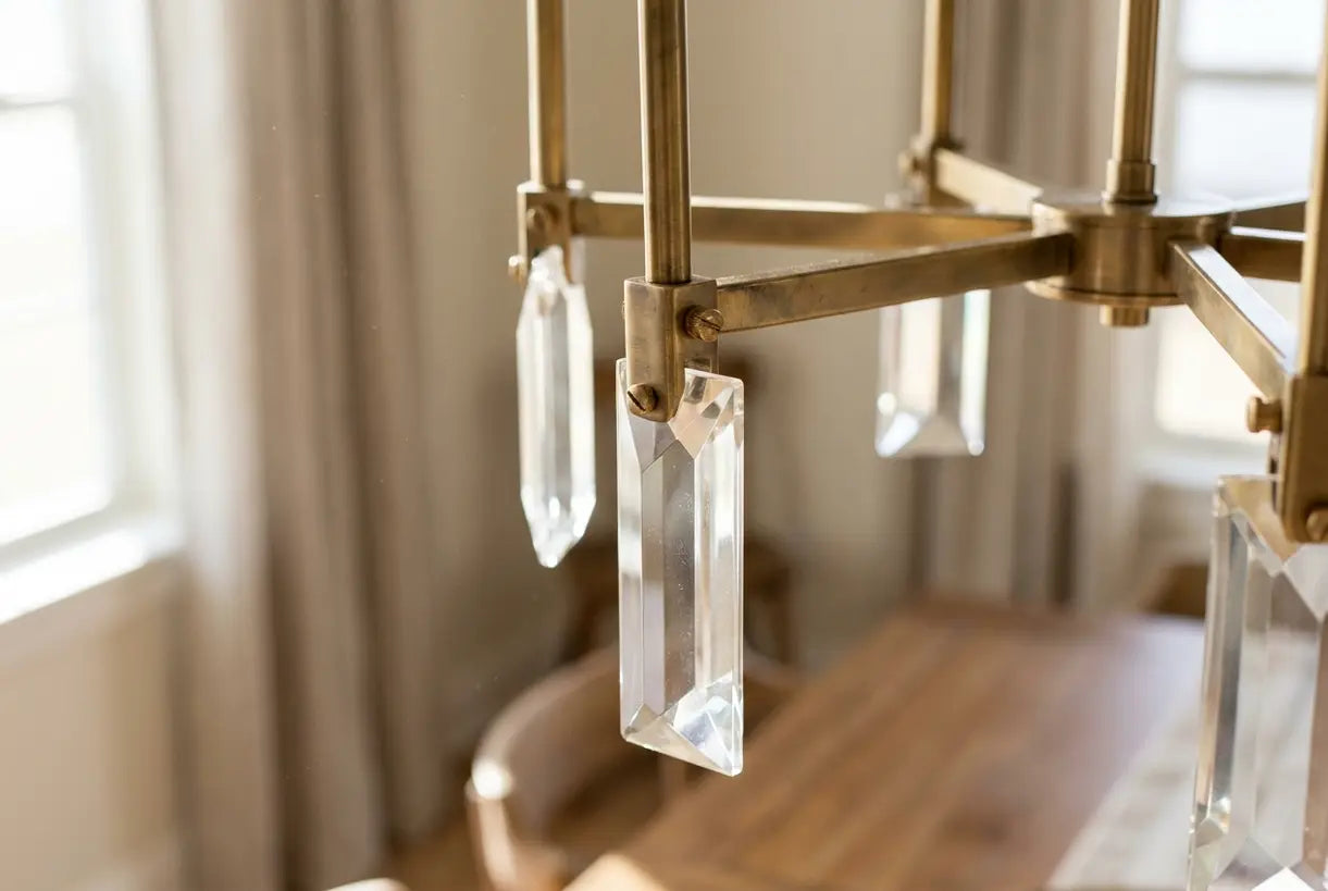 Close-up of transitional dining room chandelier showing brass hardware and crystal details