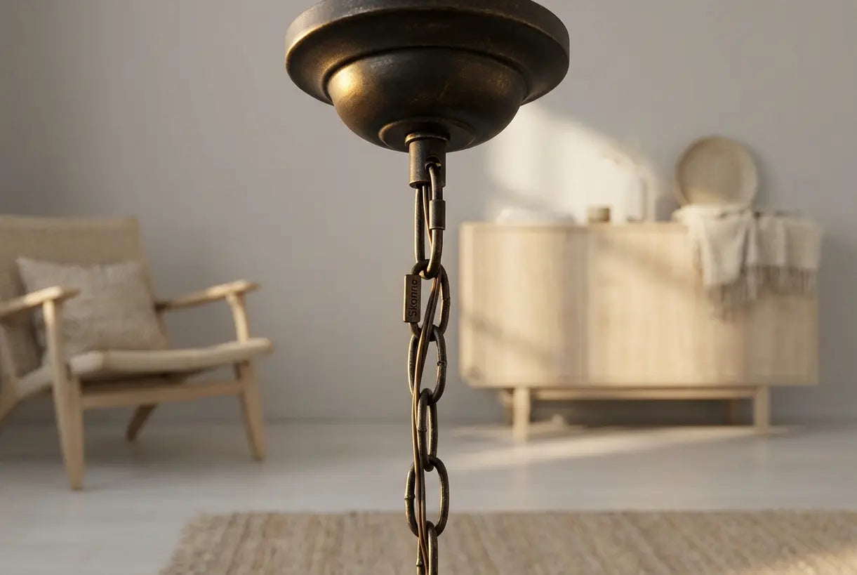 Close-up of bronze chandelier chain detail with warm metallic patina and natural light