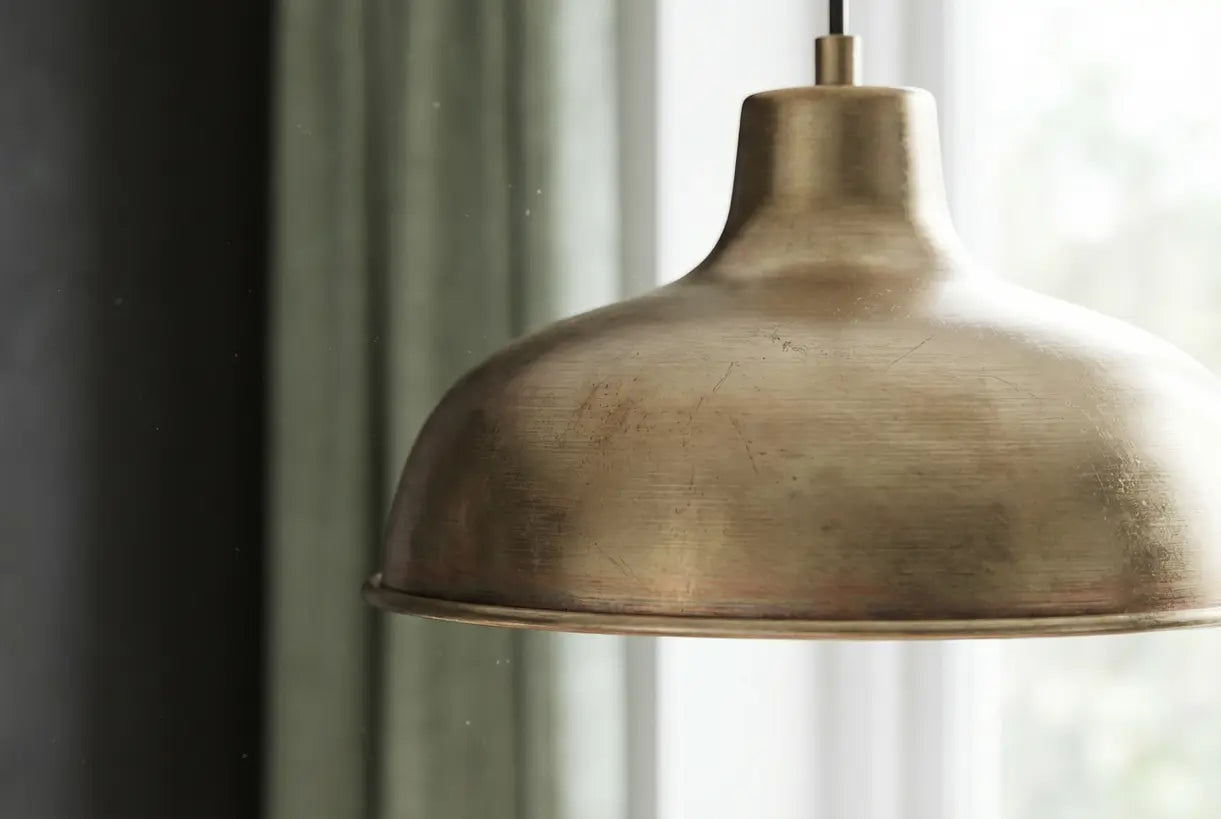 Champagne bronzen pendellamp close-up met detail van warme antieke afwerking