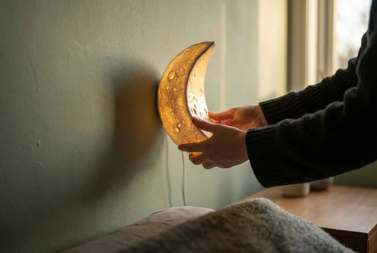 Maansikkel wandlamp wordt aangepast op saliegroene muur, warme sfeervolle gloed