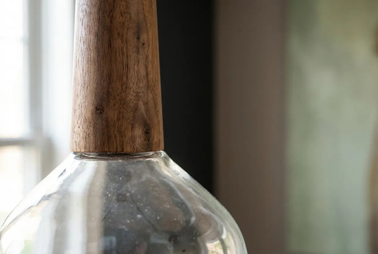 Details van pendellamp van hout en glas met natuurlijke houtnerftextuur en organisch materiaalvakmanschap