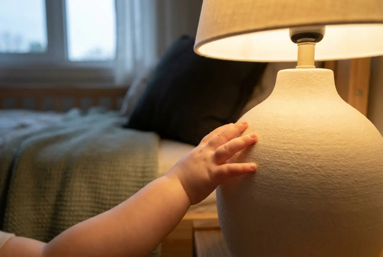Kinderhand die een veilige kindertafellamp met warme sfeerverlichting aanraakt