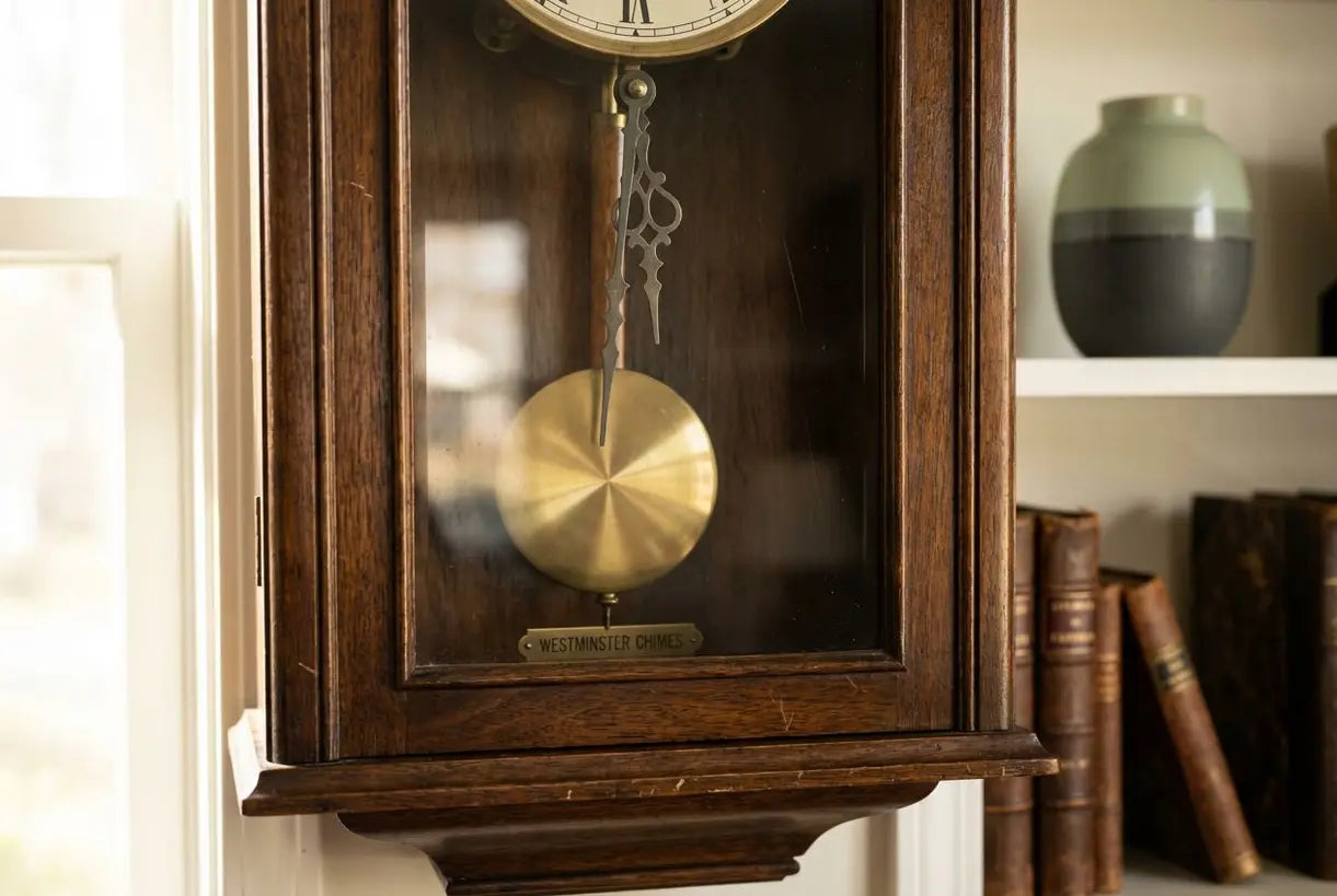 Detailopname van de slinger en wijzers van een vintage wandklok met gong die vakmanschap toont