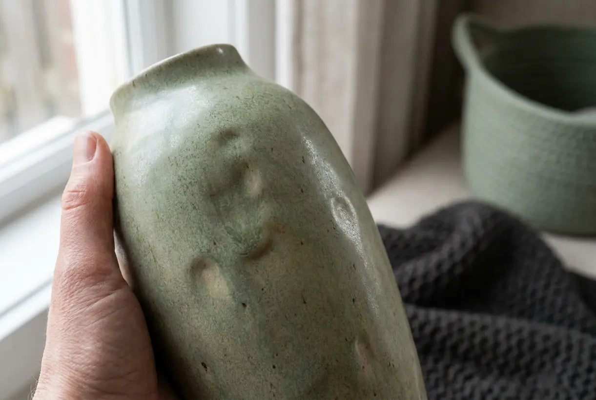 Close-up of sage green ceramic vase texture in natural light