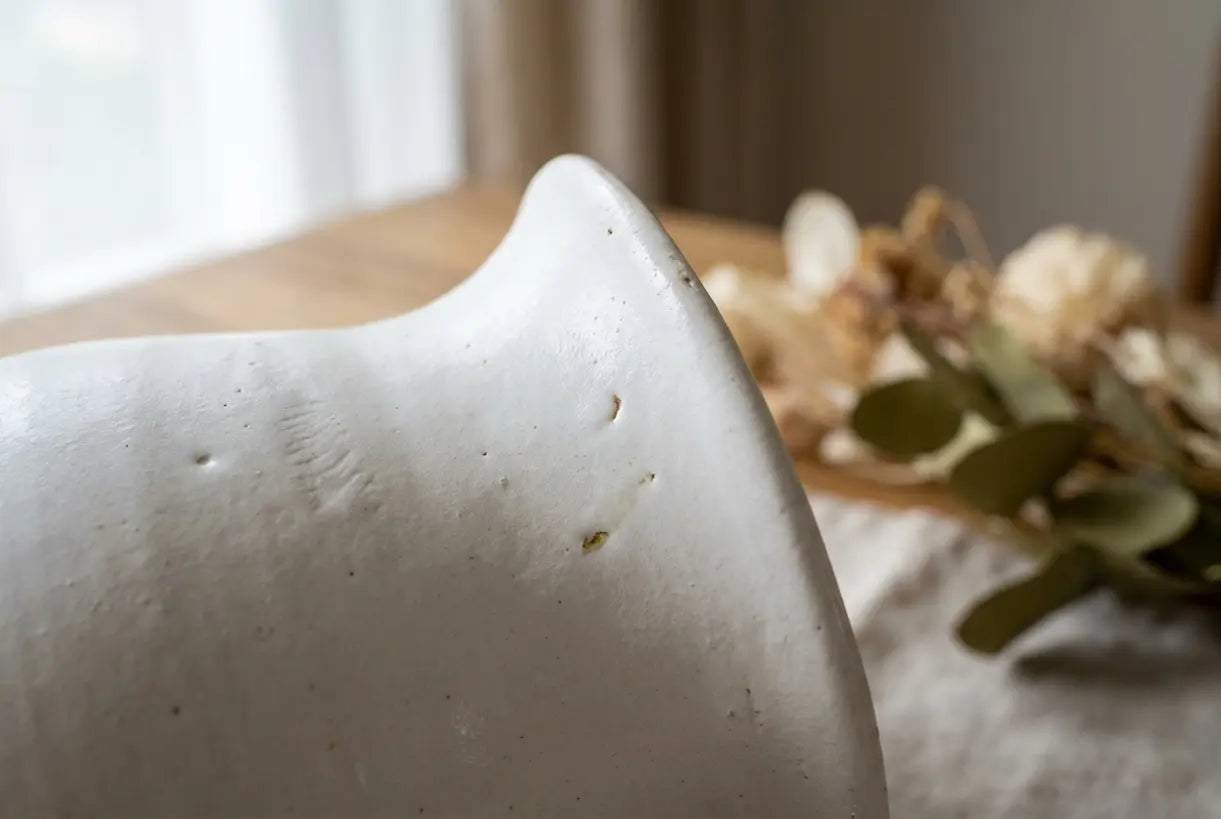 Close-up of white ceramic vase texture showing handcrafted glaze quality and artisan details