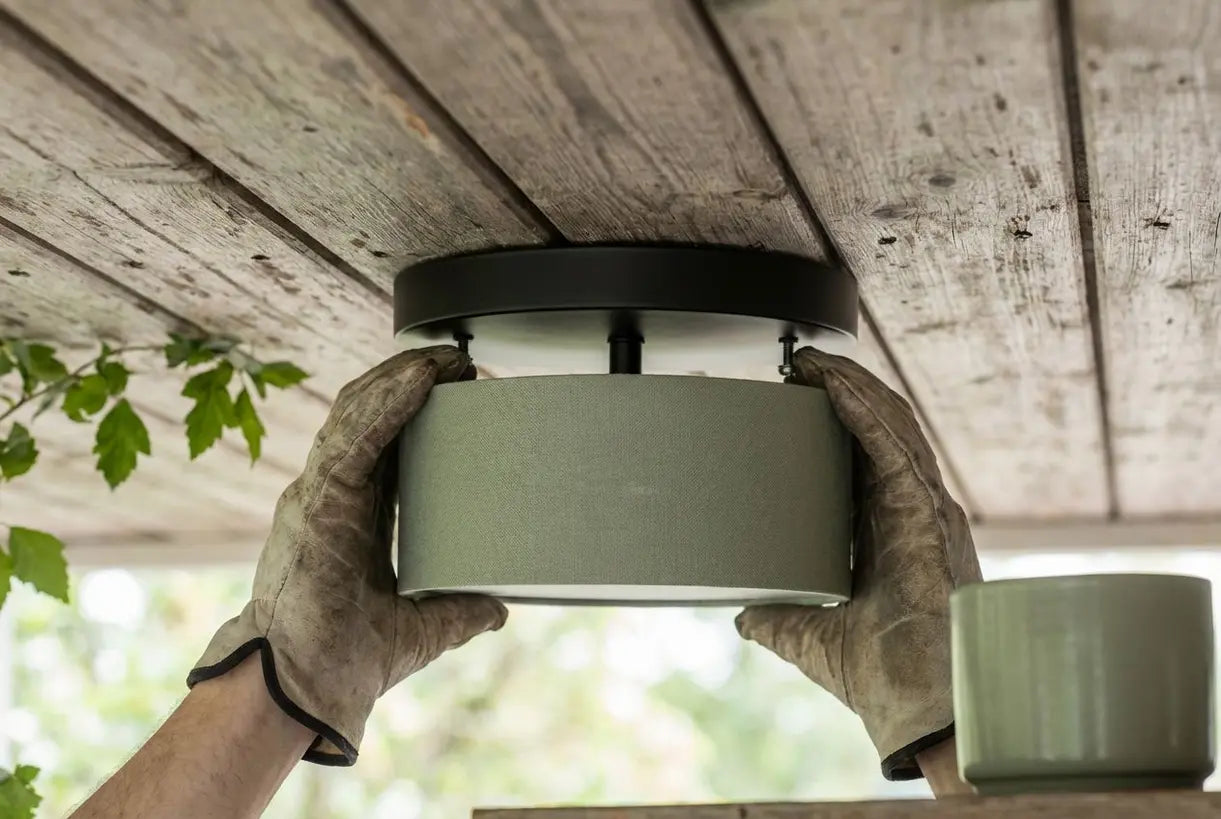 Handen installeren buitenplafondarmatuur op overdekt veranda plafond
